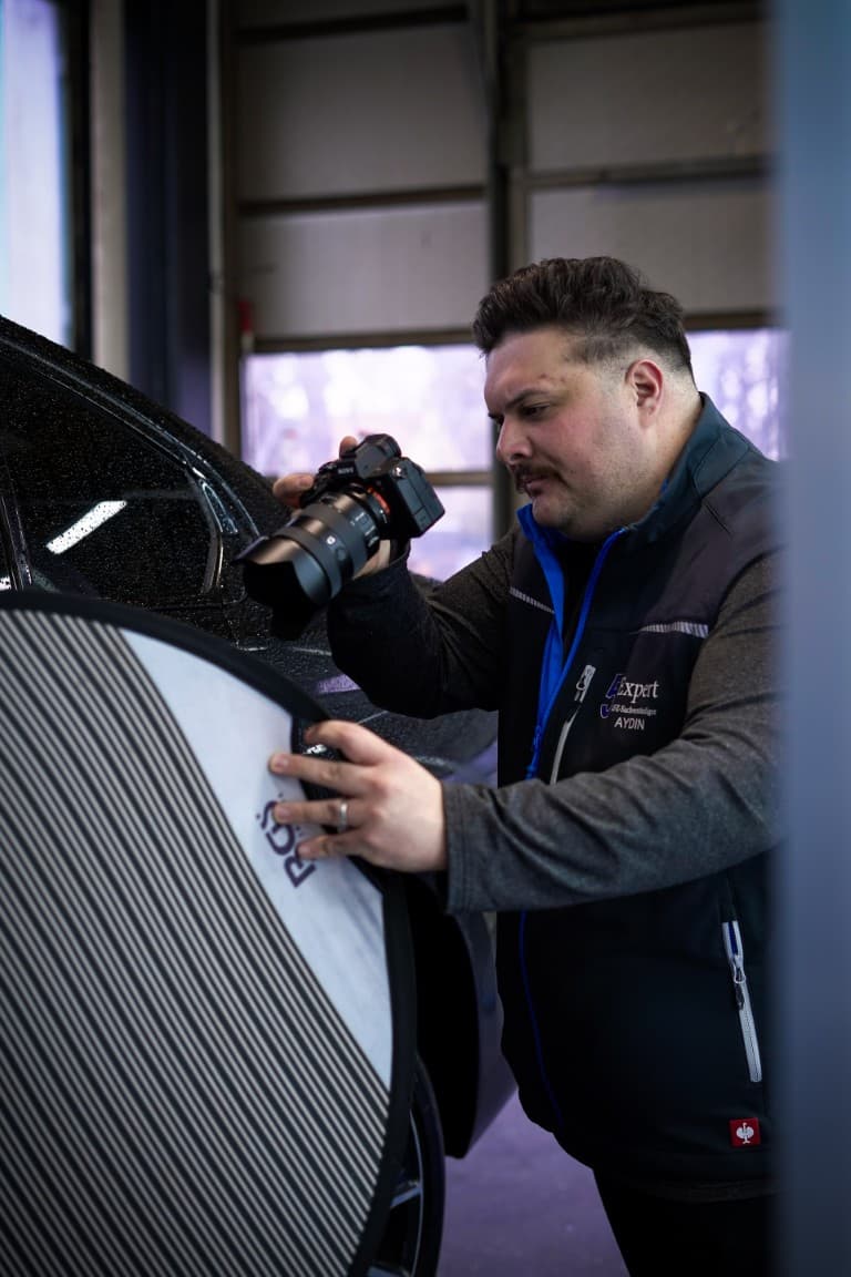 Aydin Okan dokumentiert einen Fahrzeugschaden mit der Kamera